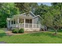 Inviting home showcasing a charming, covered porch with white railings and an outdoor seating area at 315 Jewel Ln, Covington, GA 30014