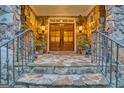 Stone front porch with iron railing, manicured landscaping, and beautiful double doors with sidelights create a welcoming entrance at 223 Old Rome Rd, Kingston, GA 30145