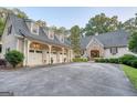 Charming home features a stone facade, three-car garage, and a circular driveway surrounded by lush landscaping at 223 Old Rome Rd, Kingston, GA 30145