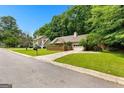 Suburban home featuring a well-maintained lawn, driveway, and mature trees at 110 Long Leaf, Peachtree City, GA 30269