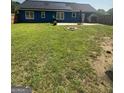 Spacious backyard with a patio, solar panels on the roof, and partial fencing at 160 Springdale Ct, Newborn, GA 30056