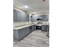 Modern kitchen featuring gray cabinetry, stainless steel appliances, and granite countertops at 4059 Canby Ln, Decatur, GA 30035