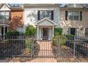 Charming townhome with a brick walkway, mature landscaping, and a black iron fence at 482 N Jeff Davis Dr, Fayetteville, GA 30214