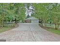 Long driveway leading to a garage, framed by trees and a picket fence at 501 Bridlepath Ln, Peachtree City, GA 30269
