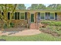 Welcoming front entrance with brick steps, shutters, and manicured shrubbery at 501 Bridlepath Ln, Peachtree City, GA 30269