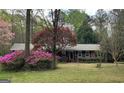Brick home featuring flowering bushes and mature trees in a serene setting at 501 Bridlepath Ln, Peachtree City, GA 30269