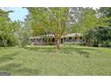 Beautifully landscaped front yard with mature trees surrounding a brick home at 501 Bridlepath Ln, Peachtree City, GA 30269