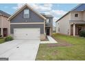 Charming two-story home featuring gray siding, a two-car garage and nicely manicured lawn at 2493 Oakleaf Rdg, Lithonia, GA 30058