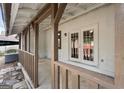 Covered porch area with wooden beams, white siding, and view of double doors at 108 Adrian Dr, Stockbridge, GA 30281