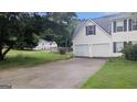 Home with a long driveway leading to a two-car garage, set against a backdrop of mature trees at 3679 Seabass Rd, Decatur, GA 30034