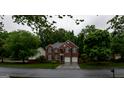 Wide shot of a brick home showcasing its curb appeal and landscaping at 8035 Magnolia Way, Roswell, GA 30075