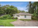 Well-maintained one-story home with a lush green lawn and mature trees surrounding the property at 1854 Shadydale Se Ave, Atlanta, GA 30315