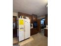 Outdated kitchen with dark wood cabinets and a white refrigerator at 1058 Viking Dr, Stone Mountain, GA 30083