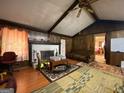 Living room with wood walls, a fireplace, and a ceiling fan at 1058 Viking Dr, Stone Mountain, GA 30083