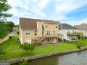 A two-story home with a wooden deck overlooking a lush green yard and canal at 105 Providence Ct, Carrollton, GA 30116