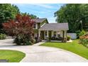 Charming two-story home showcasing lush landscaping, a well-manicured lawn, and a welcoming covered front porch at 3778 Berdon Ln, Decatur, GA 30034