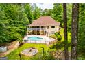 Aerial view of a backyard featuring a pool, fire pit, and wrap-around porch at 7392 N Mitchell Ct, Villa Rica, GA 30180