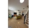 Bright living room with wood floors, a ceiling fan, a cozy fireplace, and comfortable seating at 7050 Galloway Pt, Riverdale, GA 30296