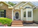 Inviting entrance with brick steps, decorative door, and bay window enhances curb appeal at 100 Riveredge Dr, Mcdonough, GA 30252