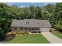 Inviting single-story home with well-manicured lawn and landscaping, nestled among mature trees at 225 Chinns Way, Hampton, GA 30228