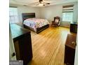 A sunlit bedroom featuring a striking wood bed frame, complemented by wood flooring and bright windows at 35 Hampton Oaks Dr, Hampton, GA 30228