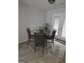 Cozy dining area featuring a glass table, four chairs, and bright natural light from the patio doors at 35 Hampton Oaks Dr, Hampton, GA 30228