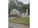Charming two-story home features a two-car garage, well-maintained lawn and mature trees at 35 Hampton Oaks Dr, Hampton, GA 30228
