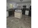 Spacious kitchen featuring light cabinets, an island, granite countertops, and stainless steel appliances at 35 Hampton Oaks Dr, Hampton, GA 30228