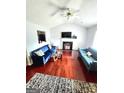 Spacious living room with a vaulted ceiling, wood floors, fireplace and well-coordinated blue sofas at 35 Hampton Oaks Dr, Hampton, GA 30228