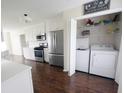 Kitchen adjacent to laundry area, showcasing modern appliances and white cabinetry at 1204 Bent Creek Dr, Mcdonough, GA 30252