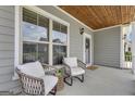 Inviting front porch with comfortable seating, wood ceiling, and charming wreath at 206 Roundwood Way, Peachtree City, GA 30269