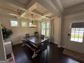 Bright dining room featuring coffered ceilings, a modern chandelier, and a large wooden dining table at 442 Snow Owl Way, Lawrenceville, GA 30044