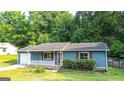 Charming one-story home with blue siding, red shutters, and a manicured front lawn at 1183 Iron Gate Blvd, Jonesboro, GA 30238