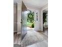 Inviting foyer with an open door view, elegant rug, and view to a tree lined neighborhood at 407 Calgary Dr, Peachtree City, GA 30269
