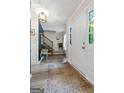 Bright foyer featuring wood floors, elegant lighting, and a staircase with wooden rails at 407 Calgary Dr, Peachtree City, GA 30269