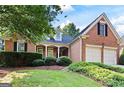 Charming brick home featuring a well-manicured lawn and two-car garage at 795 Lake Medlock, Alpharetta, GA 30022