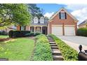 Charming brick home featuring a well-manicured lawn and two-car garage at 795 Lake Medlock, Alpharetta, GA 30022