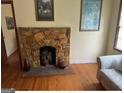 A classic stone fireplace serves as a focal point in a room with hardwood floors and cream-colored walls at 5094 Covington Hwy, Decatur, GA 30035