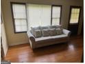 Bright living area featuring hardwood floors, a large sofa, and sunlight streaming in through the windows at 5094 Covington Hwy, Decatur, GA 30035