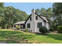 Beautifully landscaped front yard featuring lush lawn and mature trees surrounding the white brick home at 130 Emerald Dr, Mcdonough, GA 30253