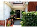 Inviting front porch adorned with lush greenery, flowers, and a decorative wreath, creating a welcoming entrance at 8180 Chapman Ter, Mcdonough, GA 30252