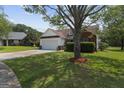 Traditional home with a spacious lawn, mature tree, and an attached two-car garage providing ample parking at 8180 Chapman Ter, Mcdonough, GA 30252