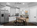 Renovated kitchen with stainless steel appliances, white cabinetry and a breakfast table, connecting to the living area at 1174 Princess Sw Ave, Atlanta, GA 30310