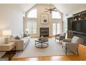Elegant living room featuring a fireplace, high ceilings, hardwood floors, and natural light at 150 Old Plantation Way, Fayetteville, GA 30214