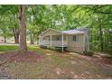 Charming single-story home featuring a welcoming front porch and well-maintained landscaping and mature trees at 438 Punkintown Rd, Villa Rica, GA 30180