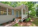 Charming front porch featuring wooden flooring, white railings, and a stylish front door at 438 Punkintown Rd, Villa Rica, GA 30180