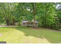 Home's front yard featuring mature trees, lush green lawn, and a charming home exterior at 438 Punkintown Rd, Villa Rica, GA 30180