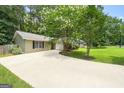 Spacious driveway leading to a well-maintained home surrounded by mature trees and lush landscaping at 409 Deergrass Trl, Peachtree City, GA 30269