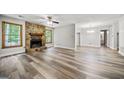 Inviting living room with a stone fireplace, wood-look floors, and ample natural light at 409 Deergrass Trl, Peachtree City, GA 30269