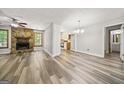 Open living area featuring hardwood flooring, a stone fireplace, and seamless flow to the kitchen at 409 Deergrass Trl, Peachtree City, GA 30269